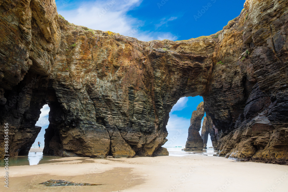 Natural rock arches Cathedrals beach, Playa de las Catedrales at Ribadeo, Galicia, Spain. Famous beach in Northern Spain Atlantic. Natural rock arch on Cathedrals beach in low tide