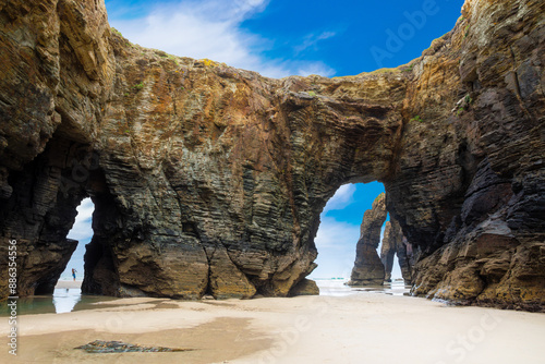 Natural rock arches Cathedrals beach, Playa de las Catedrales at Ribadeo, Galicia, Spain. Famous beach in Northern Spain Atlantic. Natural rock arch on Cathedrals beach in low tide