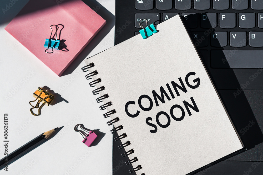 Coming Soon Note On A White Notebook On A Desk With A Laptop And Office Supplies Coming Soon Note On A White Notebook On A Desk With A Laptop And Office Supplies