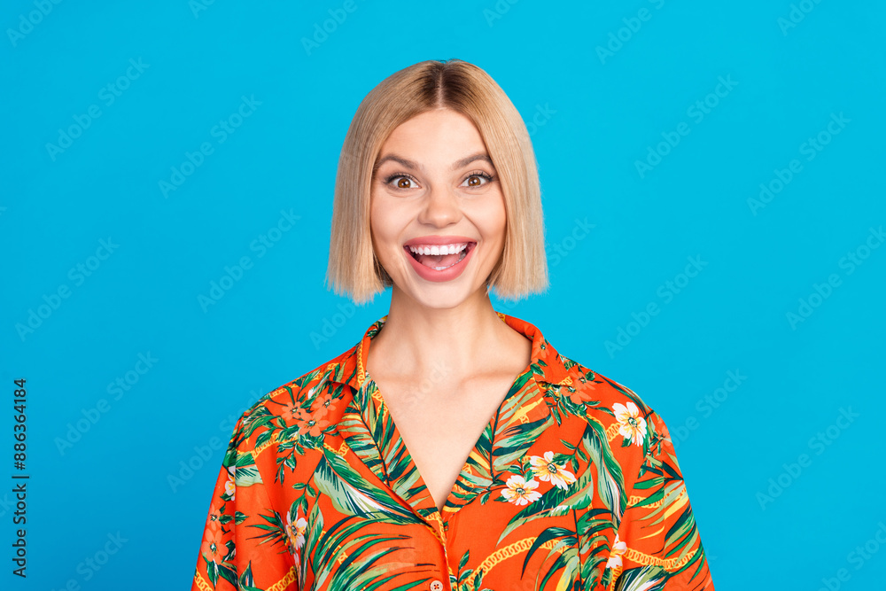 Photo of lovely cheerful nice girl wear trendy orange print clothes isolated on blue color background Photo of lovely cheerful nice girl wear trendy orange print clothes isolated on blue color background