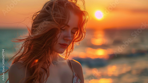 Young beautiful woman on the beach in the rays of sunset