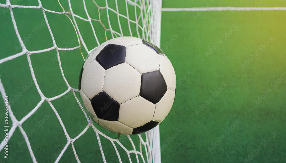 soccer ball in goal with green backgroung