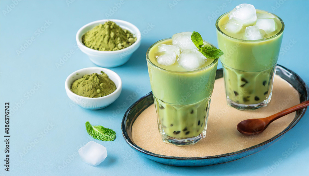 Green matcha bubble tea with ice cubes in cup on blue background. Antioxidant and dietary vegan cocktail for healthy breakfast or snack. Green matcha bubble tea with ice cubes in cup on blue background. Antioxidant and dietary vegan cocktail for healthy breakfast or snack.