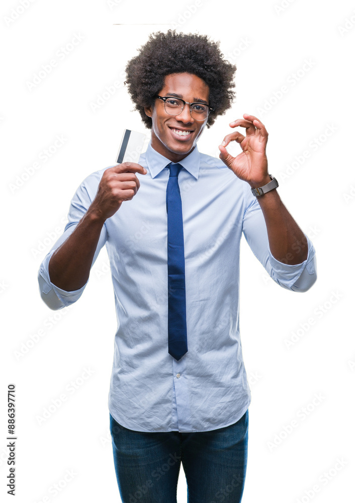 Afro american man holding credit card over isolated background doing ok sign with fingers, excellent symbol Afro american man holding credit card over isolated background doing ok sign with fingers, excellent symbol