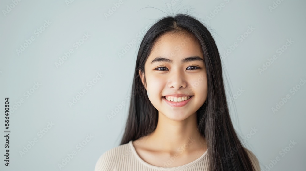 Smiling Southeast Asian Teenage Girl with Long Black Hair Against Plain Background, Perfect for Stock Photography and Design Smiling Southeast Asian Teenage Girl with Long Black Hair Against Plain Background, Perfect for Stock Photography and Design