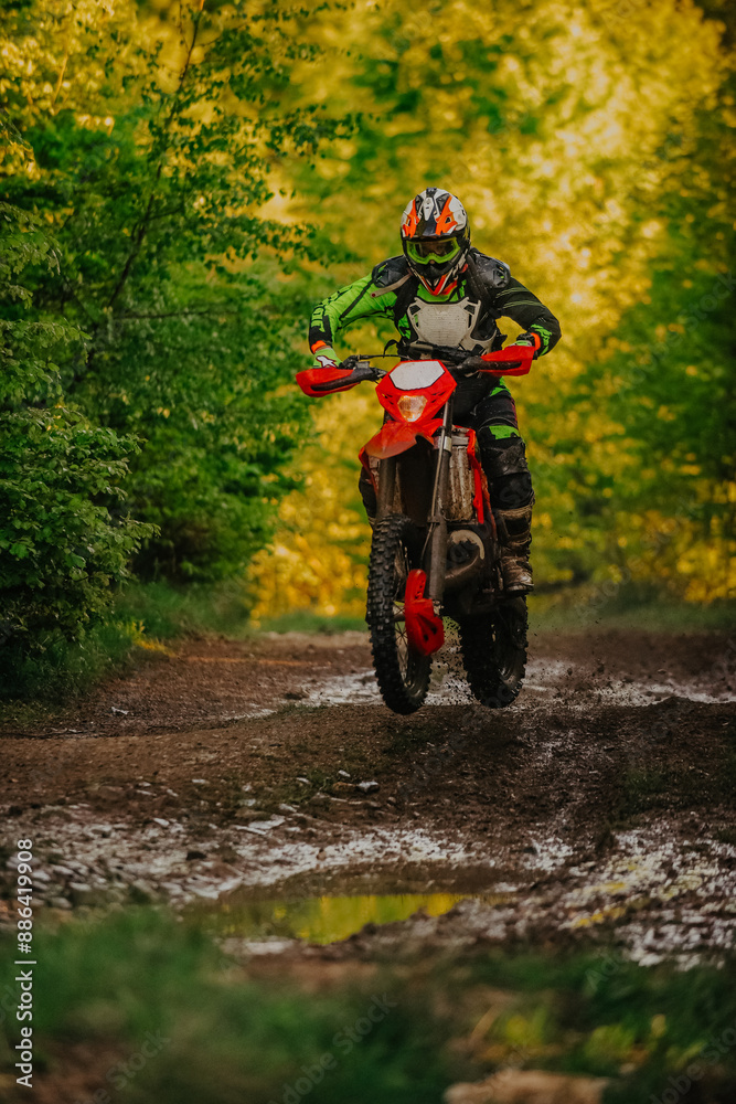 Professional enduro bike rider on action, dirt ride on the muddy road. Motocross sport. Professional enduro bike rider on action, dirt ride on the muddy road. Motocross sport.