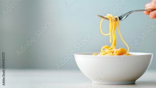 A minimalist composition of a single spaghetti strand twirling around a fork. photo