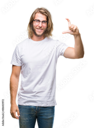 Young handsome man with long hair wearing glasses over isolated background smiling and confident gesturing with hand doing size sign with fingers while looking and the camera. Measure concept.