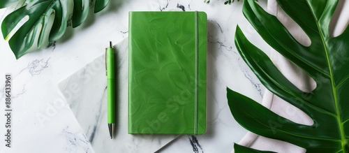 A green notebook and pen on...