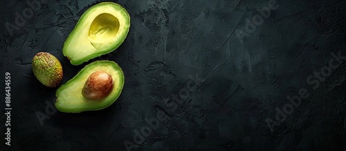 Half an avocado on a black ...