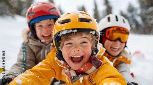 A group of children wearing helmets enjoys a thrilling sledding ride down a snowy mountain, focusing on fun and safety, with the lead child in a vibrant yellow helmet and jacket.