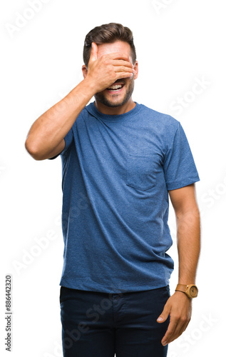 Young handsome man over isolated background smiling and laughing with hand on face covering eyes for surprise. Blind concept.