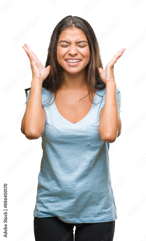 Young beautiful arab woman over isolated background celebrating mad and crazy for success with arms raised and closed eyes screaming excited. Winner concept Young beautiful arab woman over isolated background celebrating mad and crazy for success with arms raised and closed eyes screaming excited. Winner concept