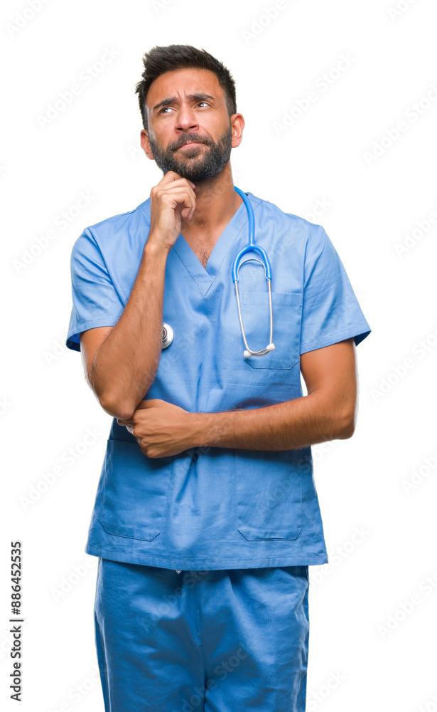 Adult hispanic doctor or surgeon man over isolated background with hand on chin thinking about question, pensive expression. Smiling with thoughtful face. Doubt concept. Adult hispanic doctor or surgeon man over isolated background with hand on chin thinking about question, pensive expression. Smiling with thoughtful face. Doubt concept.