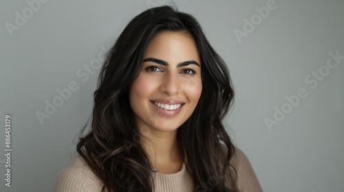 Confident Young Woman with Dark Hair and Warm Smile in Neutral Sweater, Perfect for Professional and Marketing Use