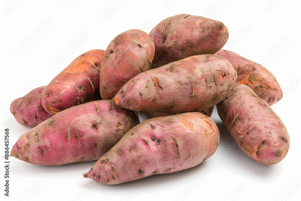 A pile of fresh, purple sweet potatoes on a white background A pile of fresh, purple sweet potatoes on a white background