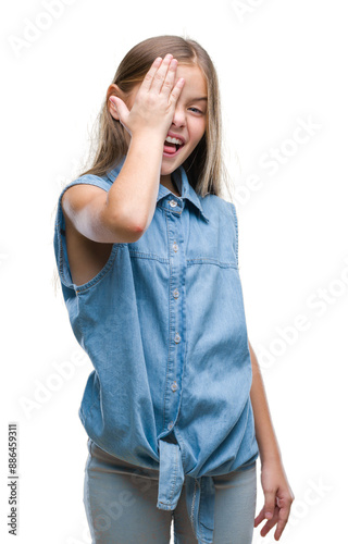 Young beautiful girl over isolated background covering one eye with hand with confident smile on face and surprise emotion.