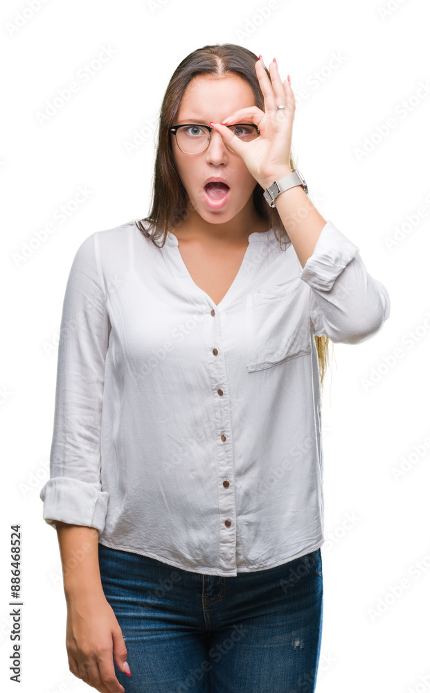 Young caucasian beautiful business woman wearing glasses over isolated background doing ok gesture shocked with surprised face, eye looking through fingers. Unbelieving expression. Young caucasian beautiful business woman wearing glasses over isolated background doing ok gesture shocked with surprised face, eye looking through fingers. Unbelieving expression.