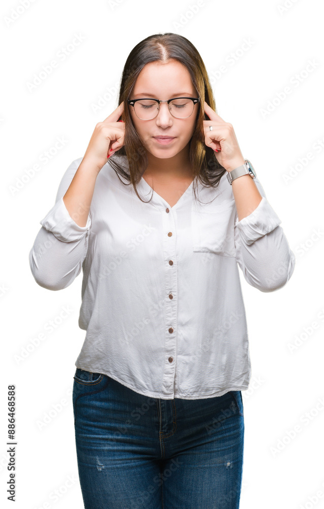 Young caucasian beautiful business woman wearing glasses over isolated background covering ears with fingers with annoyed expression for the noise of loud music. Deaf concept. Young caucasian beautiful business woman wearing glasses over isolated background covering ears with fingers with annoyed expression for the noise of loud music. Deaf concept.