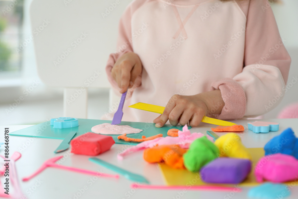 Little girl sculpting with play dough at table indoors, closeup Little girl sculpting with play dough at table indoors, closeup