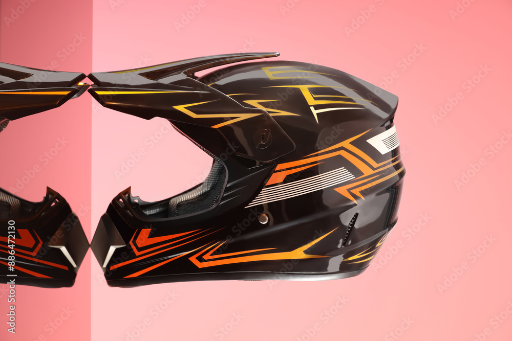 Modern motorcycle helmet with visor on mirror surface against pink background Modern motorcycle helmet with visor on mirror surface against pink background