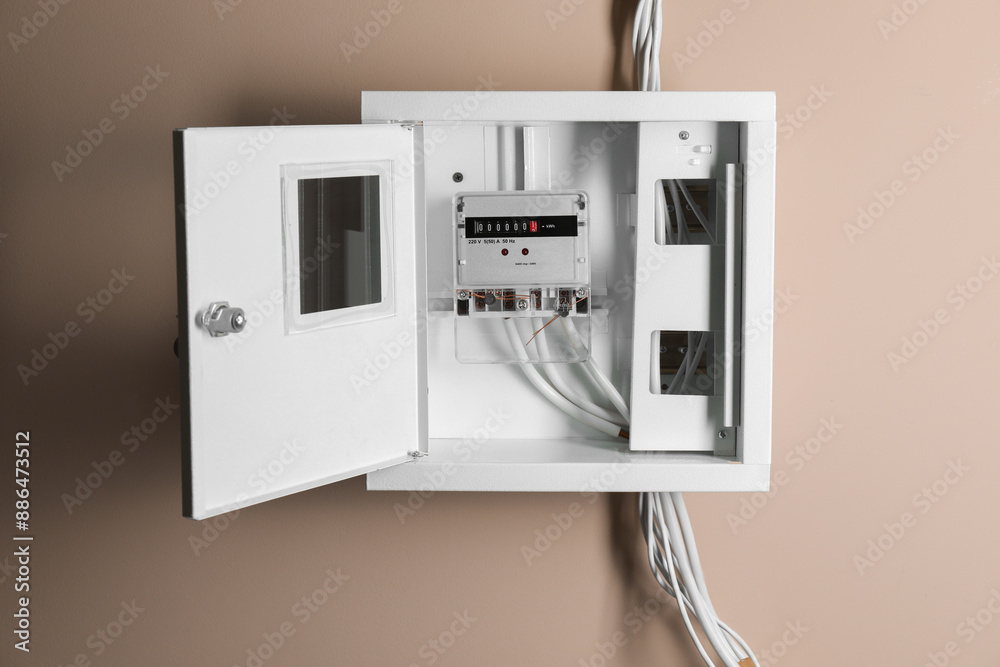 Electric meter in fuse box on beige wall. Energy measuring device Electric meter in fuse box on beige wall. Energy measuring device