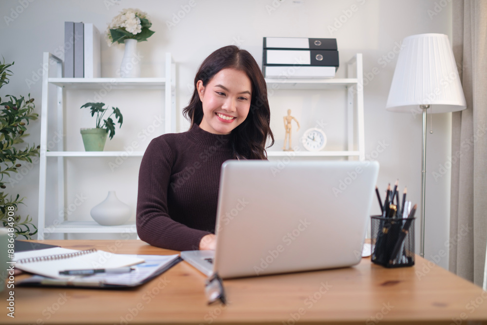 Charming young woman working with laptop while sitting at comfortable workplace. Charming young woman working with laptop while sitting at comfortable workplace.