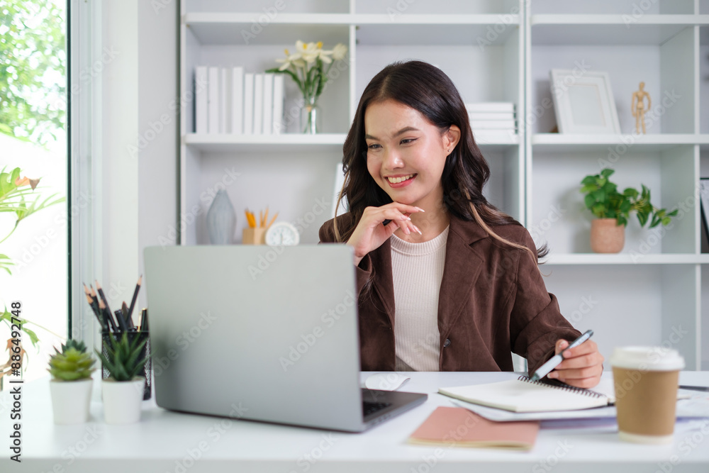 A young female administrative assistant making notes of working planning organizing information in her office. A young female administrative assistant making notes of working planning organizing information in her office.