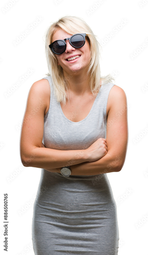 Young beautiful blonde woman wearing sunglasses over isolated background happy face smiling with crossed arms looking at the camera. Positive person. Young beautiful blonde woman wearing sunglasses over isolated background happy face smiling with crossed arms looking at the camera. Positive person.