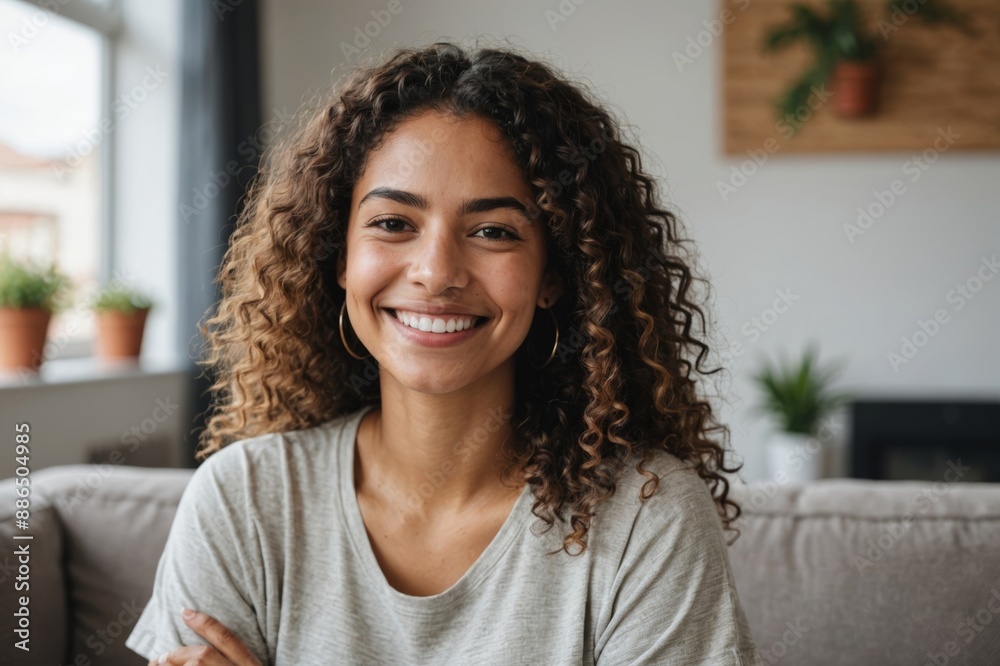 Young latin woman smiling while sitting at home