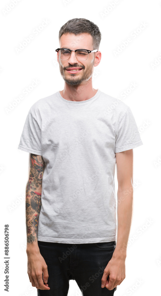Young tattooed adult man winking looking at the camera with sexy expression, cheerful and happy face. Young tattooed adult man winking looking at the camera with sexy expression, cheerful and happy face.
