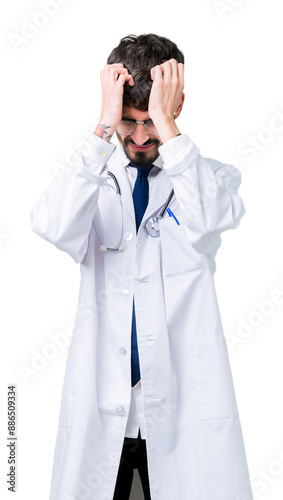 Young doctor man wearing hospital coat over isolated background suffering from headache desperate and stressed because pain and migraine. Hands on head.