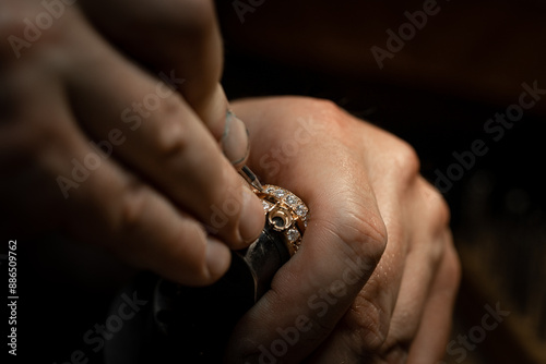 Jeweler puts diamond to golden wedding luxury ring.