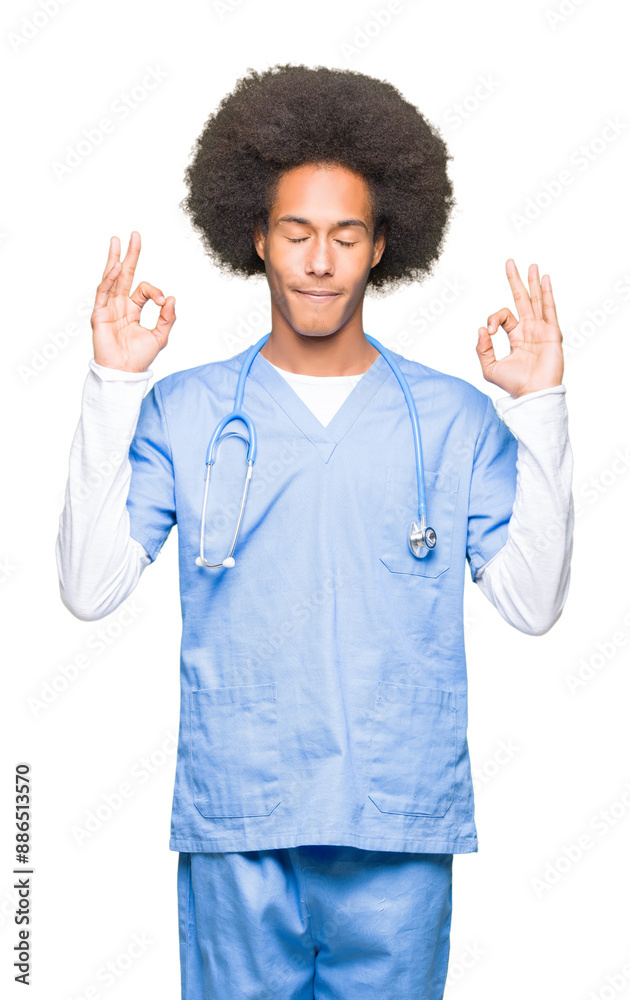 Young african american doctor man with afro hair relax and smiling with eyes closed doing meditation gesture with fingers. Yoga concept. Young african american doctor man with afro hair relax and smiling with eyes closed doing meditation gesture with fingers. Yoga concept.