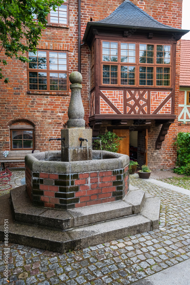 Fototapeta premium Fountain in the courtyard of the longhouse of the Holy Spirit Church in Wismar