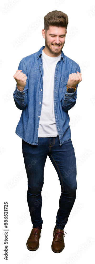 Young handsome blond man wearing casual denim jacket very happy and excited doing winner gesture with arms raised, smiling and screaming for success. Celebration concept. Young handsome blond man wearing casual denim jacket very happy and excited doing winner gesture with arms raised, smiling and screaming for success. Celebration concept.