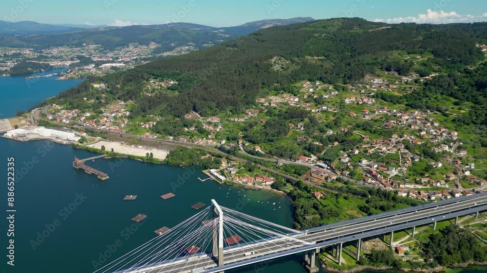 Panoramic aerial view of Vigo landscape. View of Rande Bridge and Vigo Ria. Mussels farming structures in the middle of the water. Beautiful Galician green landscape. Drone forward over the bridge. Panoramic aerial view of Vigo landscape. View of Rande Bridge and Vigo Ria. Mussels farming structures in the middle of the water. Beautiful Galician green landscape. Drone forward over the bridge.