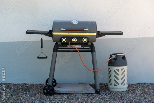 Gas grill and gas cylinder in back garden