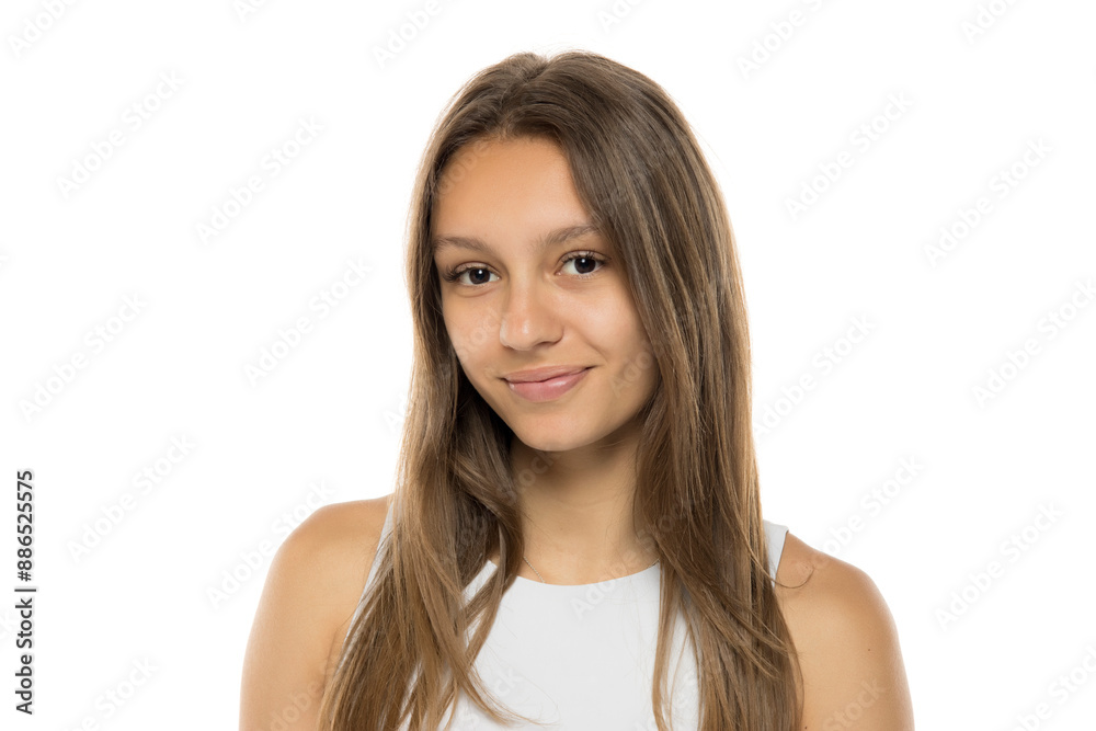Portrait of beautiful young smiling brunette woman without makeup on white studio wall. Pretty female with straight hair in white shirt Portrait of beautiful young smiling brunette woman without makeup on white studio wall. Pretty female with straight hair in white shirt