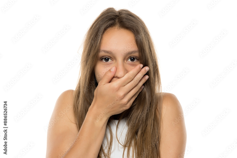 portrait of a young shocked teenage girl without makeup on a white studio background. portrait of a young shocked teenage girl without makeup on a white studio background.