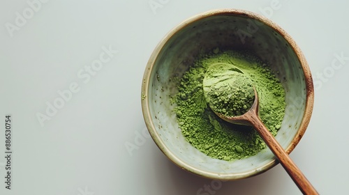 Wooden spoon with powdered matcha green tea in bowl, isolated on white. 