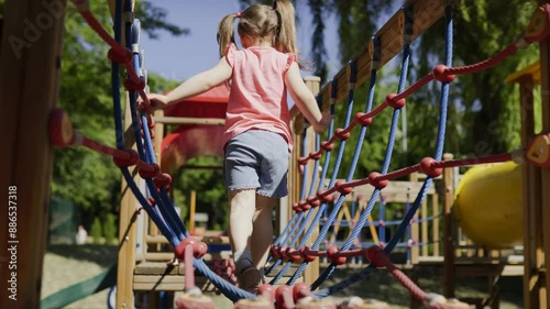 Happy Girl Playing on the Swing Set in the Playground