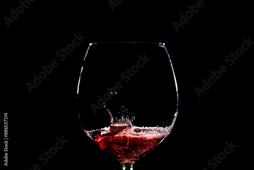 Obraz na płótnie goccia che cade all'interno di un calice riempito poco con del vino rosso su sfondo nero e crea uno schizzo con forme casuali w salonie