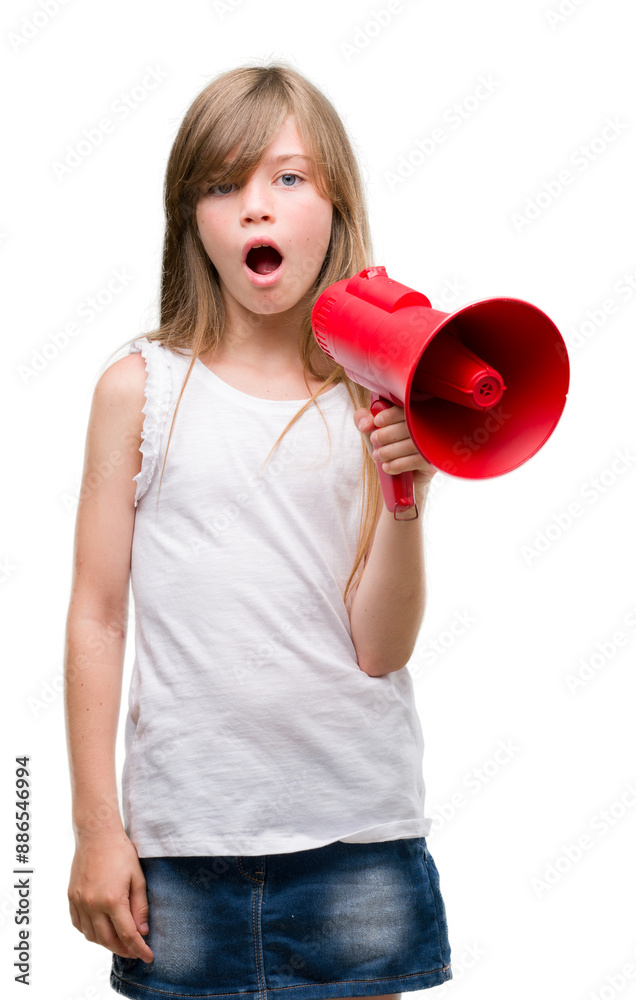 Young blonde toddler holding megaphone scared in shock with a surprise face, afraid and excited with fear expression Young blonde toddler holding megaphone scared in shock with a surprise face, afraid and excited with fear expression