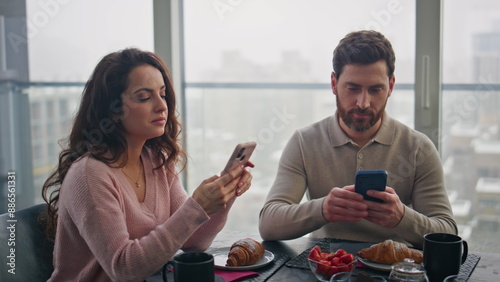 Bild auf Leinwand Internet addicted couple ignoring each other sitting at gloomy cityscape home