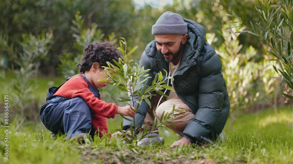 A heartwarming moment as a father teaches his young child to plant a seedling in the family garden, showcasing bonding and education. A heartwarming moment as a father teaches his young child to plant a seedling in the family garden, showcasing bonding and education.
