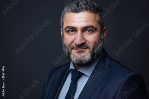 Close-up portrait of a middle aged man of Middle Eastern descent, studio photo, against a sleek gray studio backdrop