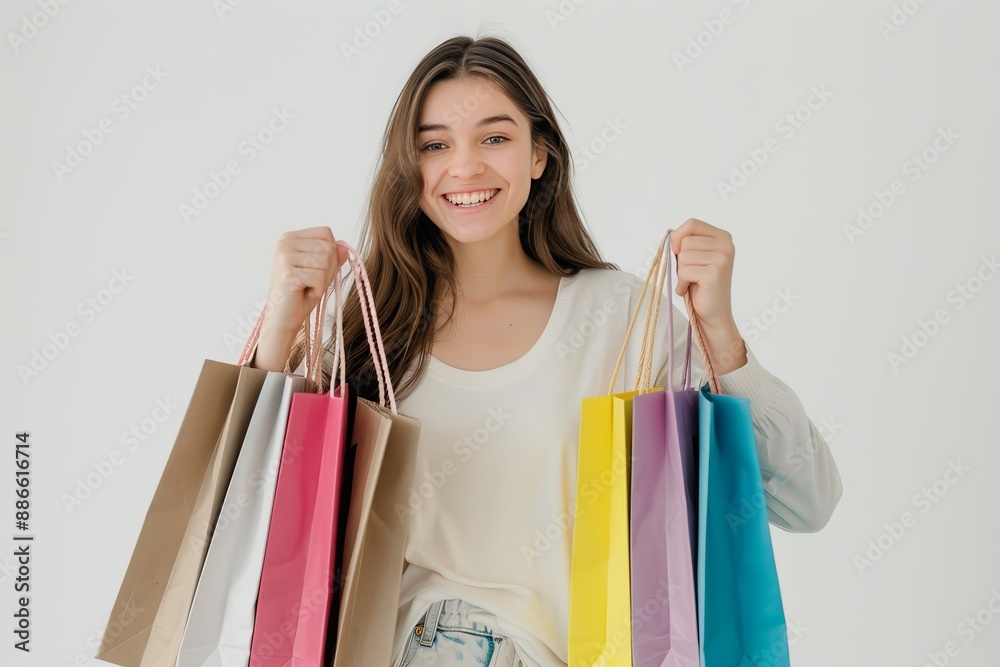 A woman holding multiple shopping bags smiling at the camera. Happy with the low price offered during sale. A woman holding multiple shopping bags smiling at the camera. Happy with the low price offered during sale.