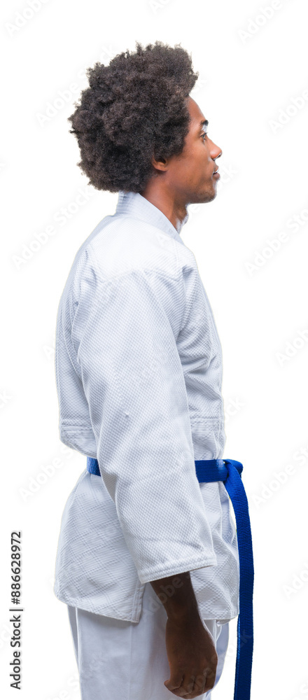 Afro american man wearing karate kimono over isolated background looking to side, relax profile pose with natural face with confident smile. Afro american man wearing karate kimono over isolated background looking to side, relax profile pose with natural face with confident smile.