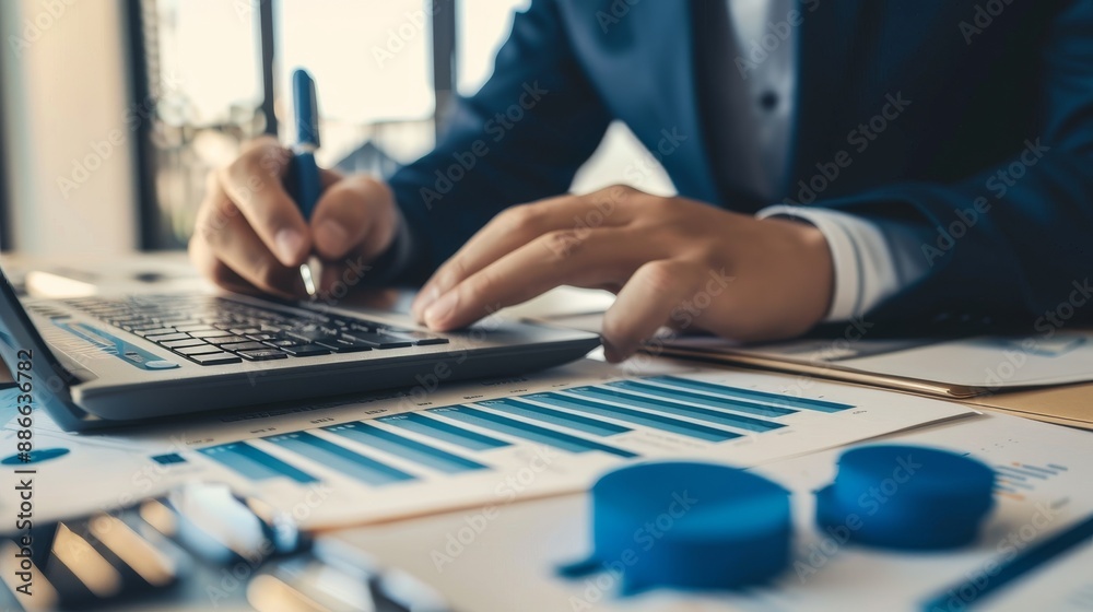 Fototapeta premium male hands typing on a laptop with graphs, accountant work concept